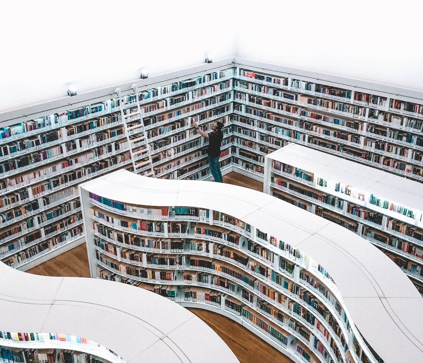 a photo with a man searching something in a curved library