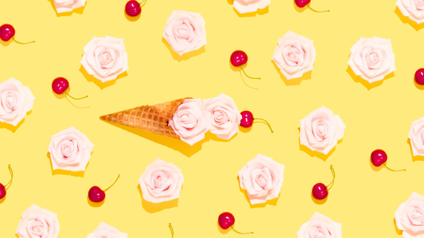 an ice-cream in the centre with cherries around it at the yellow background 