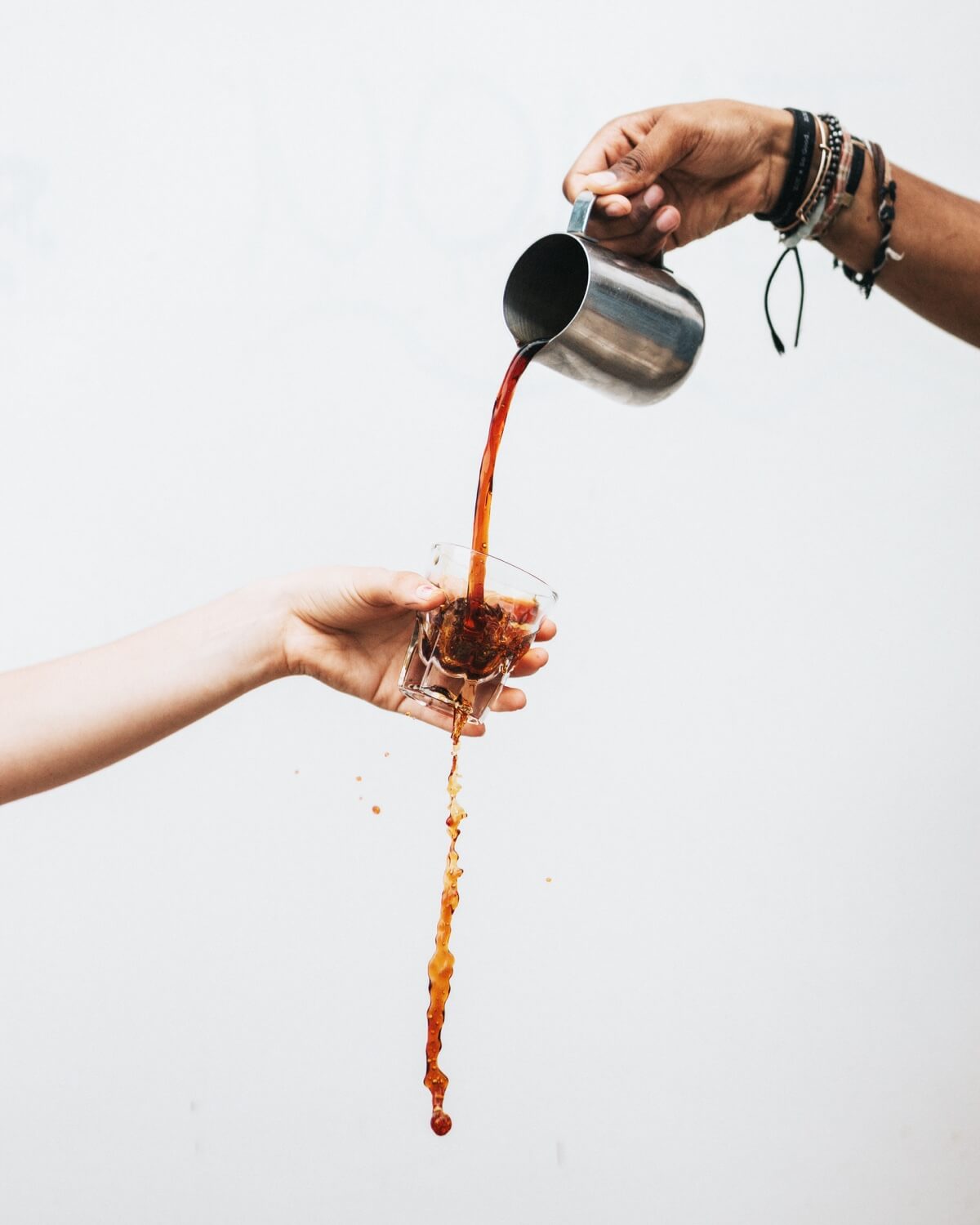 someone pouring a coffee in a glass