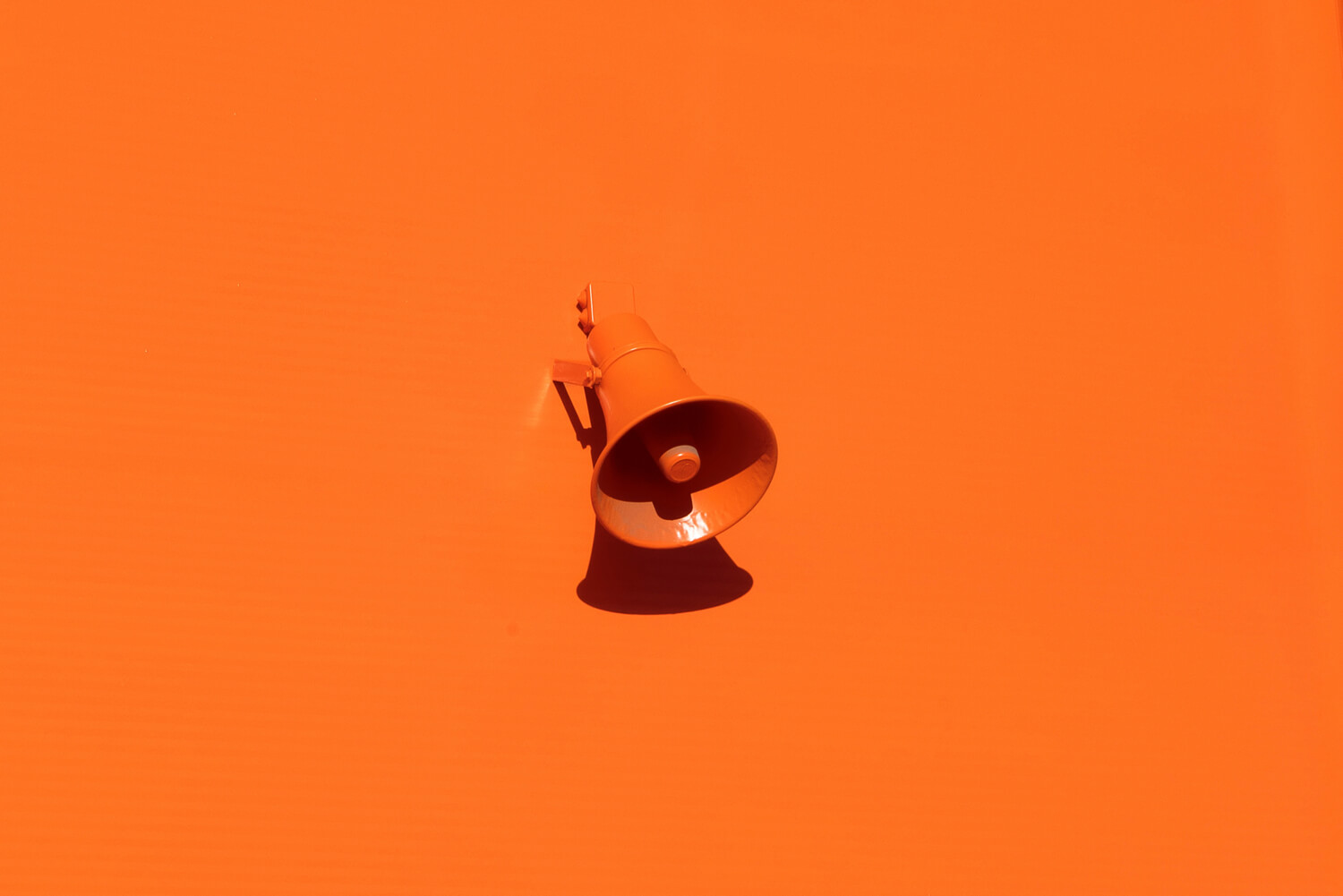 a photo of an orange megaphone at the orange backgroound