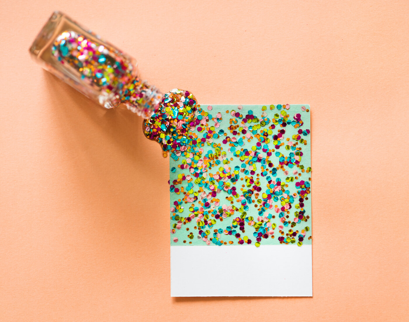 a bottle with seom confetti falling out of it