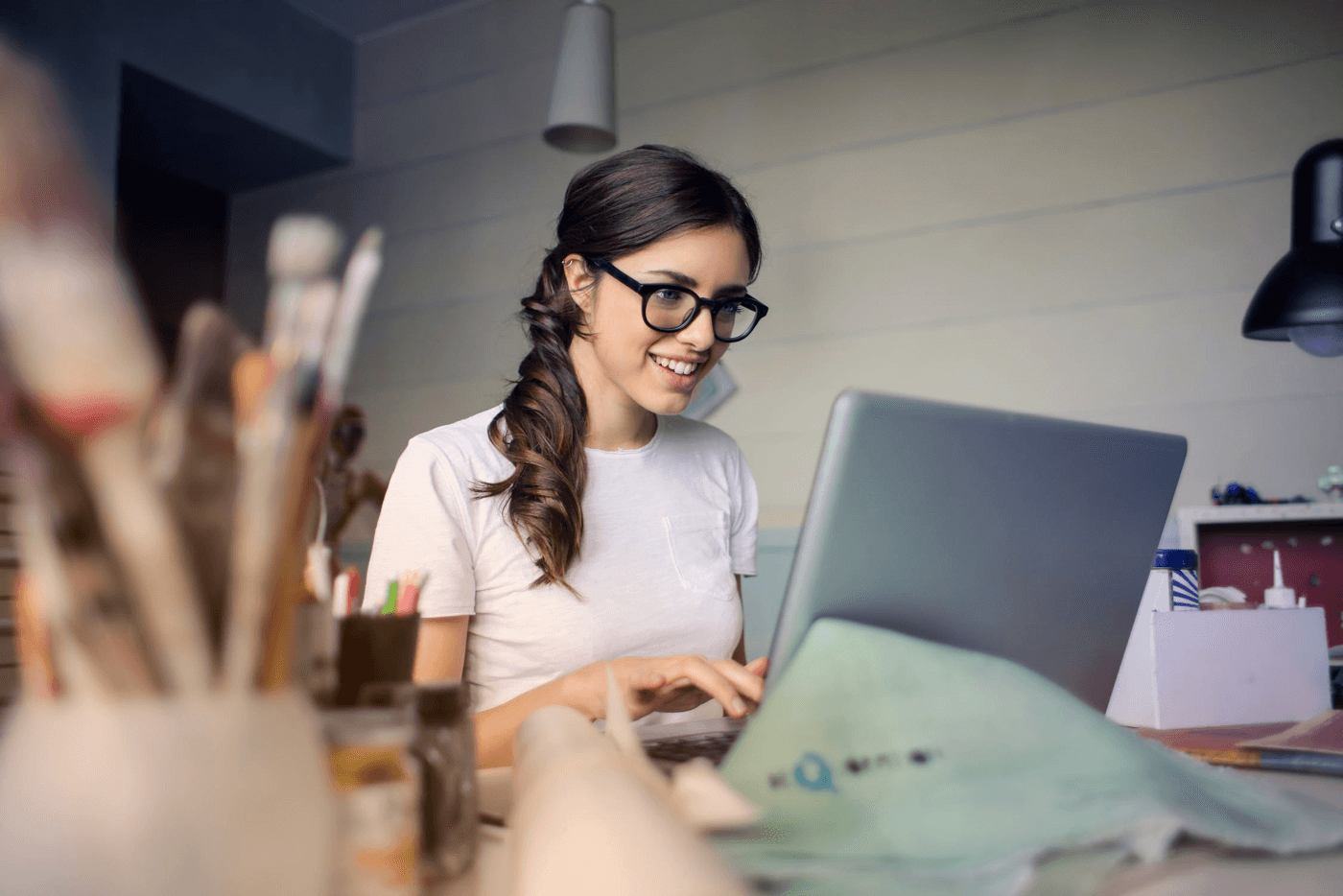 a happy girl wearing glasses with a notebook